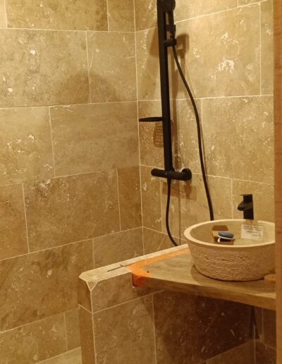 Rénovation de salle de bain en travertin par les équipes de la Maçonnerie Ribeiro en Dordogne